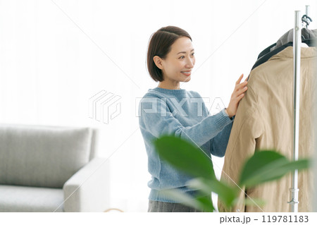 洋服をハンガーにかける女性 119781183