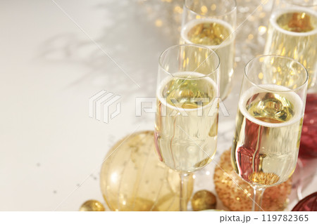 Glasses of champagne with Christmas balls on a light background 119782365