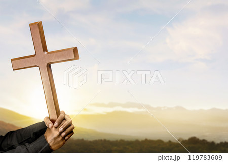 Man holding a religion cross with sunlight background. Symbol of faith and worship in God. People christianity prayer 119783609