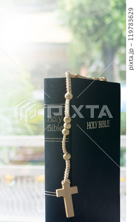 Book of Holy Bible and rosary beads. Symbol of faith and worship in God 119783629