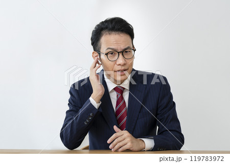 イヤホンをつけたカメラ目線のアラフォーのビジネスマン 119783972