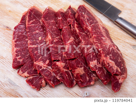 close up of pieces of marbled beef on wooden table 119784041