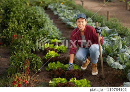 Woman with a hoe in the garden Woman with a hoe in the garden 119784103