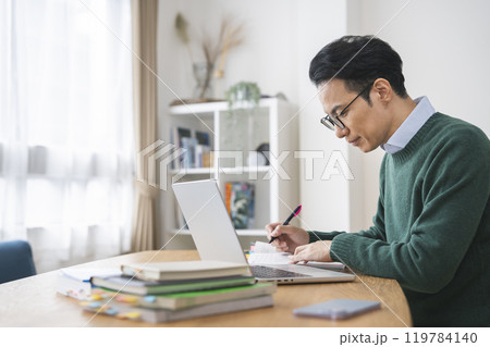 デスクで作業をする30代後半の男性　 119784140