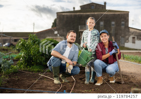 Man woman and boy planting seeds in field 119784257