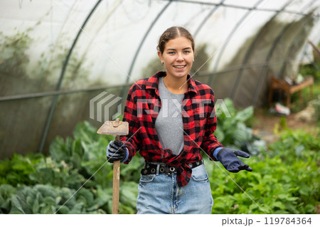 Farmer peasant woman works with garden plants in greenhouse Farmer peasant woman works with garden plants in greenhouse 119784364