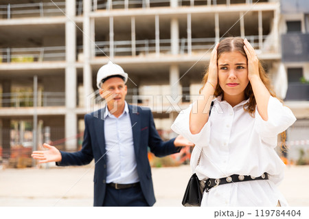 Depressed woman having problems at construction site 119784404