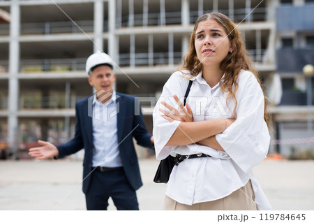Upset young woman and egineer in construction plant Upset young woman and egineer in construction plant 119784645