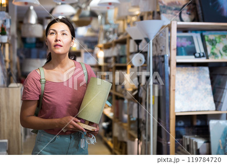 Asian woman choosing table lamp at store 119784720