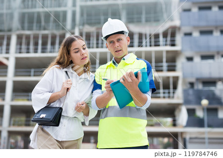 Enginner and woman discussing documentation 119784746