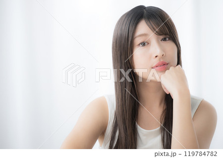 顎に手を当てる、頬杖をつくあざといポーズのカメラ目線の若いかわいい女性 119784782