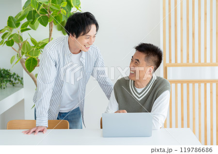 リビングでパソコンを教わるシニア男性 119786686