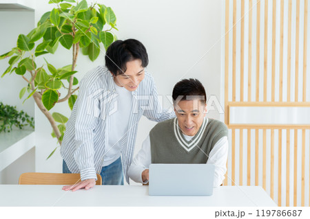 リビングでパソコンを教わるシニア男性 119786687