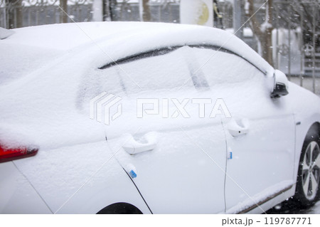 This is a scene of a car buried in snow on a snowy day. 119787771