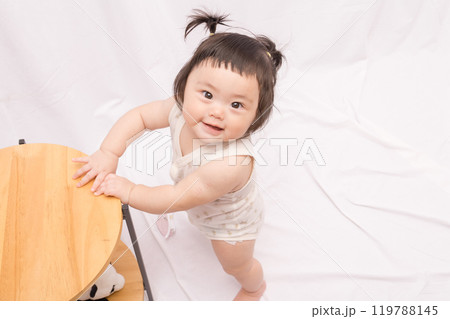 【テーブルでつかまり立ちをするツインテールの赤ちゃん】 【テーブルでつかまり立ちをするツインテールの赤ちゃん】 119788145