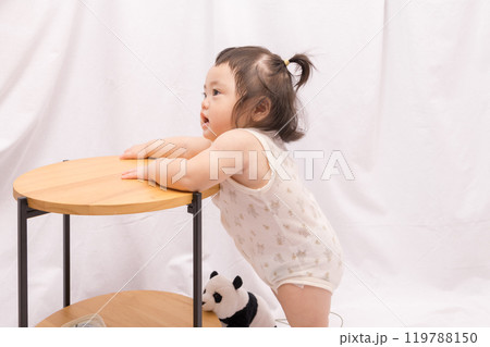 【テーブルでつかまり立ちをするツインテールの赤ちゃん】 【テーブルでつかまり立ちをするツインテールの赤ちゃん】 119788150