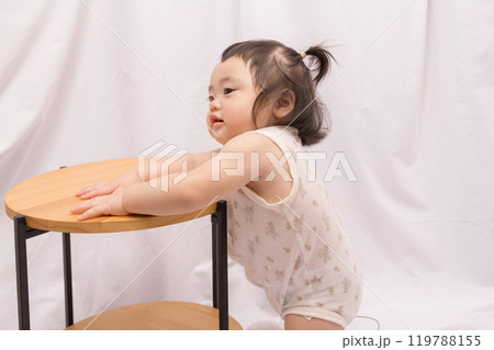 【テーブルでつかまり立ちをするツインテールの赤ちゃん】 【テーブルでつかまり立ちをするツインテールの赤ちゃん】 119788155