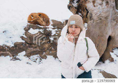 Woman tourist with Cute fox on snow in winter season at Zao fox village, traveler sightseeing Miyagi prefecture. landmark and popular for attraction near Sendai, Tohoku, Japan. Travel and Vacation 119790069