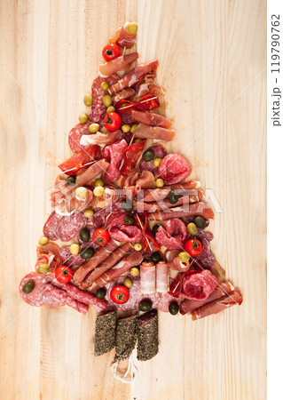 Christmas tree made of sausage on a background of a wooden wall 119790762