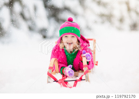 Child playing with snow in winter. Kids outdoors. 119792170