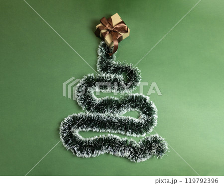 Christmas garland nested in the form of a Christmas tree with a gift box with a brown bow Christmas garland nested in the form of a Christmas tree with a gift box with a brown bow 119792396