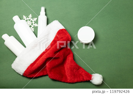 cosmetics fall out of Santa Claus hat on a green background 119792426