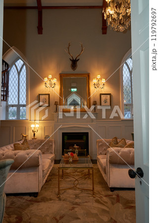 Splendid chandelier with lit candles in a beautiful room of an old mansion 119792697
