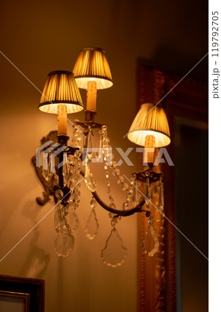 Splendid chandelier with lit candles in a beautiful room of an old mansion 119792705