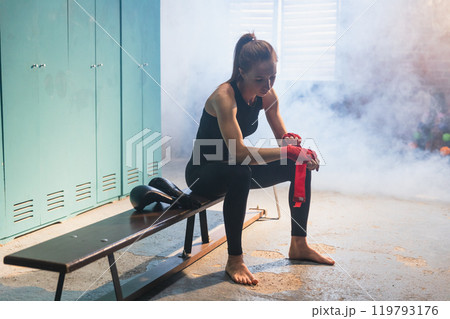 Women self defense girl power. Woman fighter preparing for fight wrapping hands with red boxing wraps sports protective bandages. Strong girl ready for fight active exercise sparring workout training 119793176