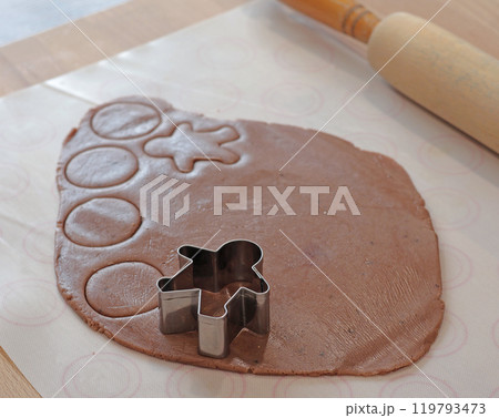 Rolled out gingerbread dough for Christmas gingerbread men. Holiday and cooking at home in the kitchen. 119793473