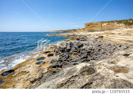 Crystal clear turquoise water in blue lagoon. St. Peters pool - rocky beach at Malta Crystal clear turquoise water in blue lagoon. St. Peters pool - rocky beach at Malta 119793533