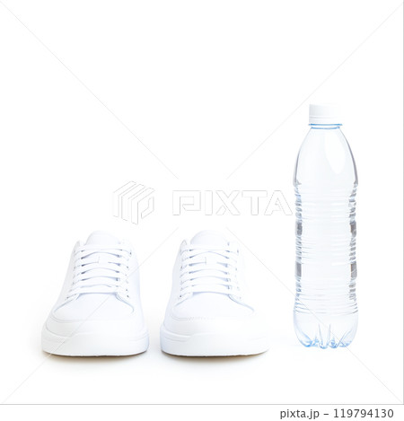 Stylish White Sneakers Beside a Water Bottle 119794130