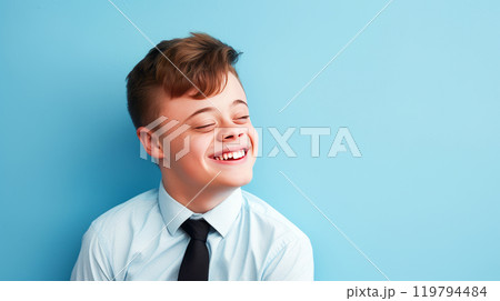 Portrait of smiling laughing teenager guy with Down syndrome blue background. 119794484