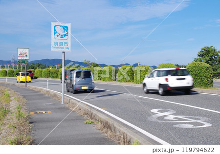 鳥取県境港市の米子鬼太郎空港沿いのメロディー道路を自動車が次々と通過する光景 119794622