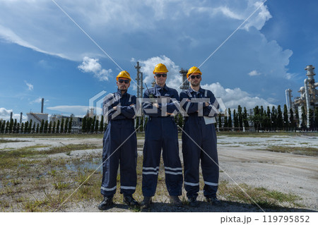 portrait of teamwork professional electrical engineer safety uniform each other together standing refining oil petrochemical industry. Technician worker at zone gas with refinery building background. 119795852