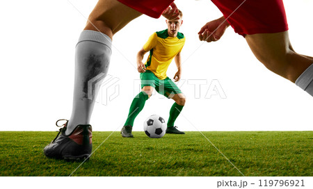 two soccer players in green and red uniforms struggling for ball possession, illustrating fierce energy and tension of game, on green soccer stadium. 119796921