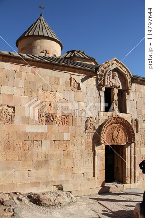 Facade of a historic stone church with intricate carvings and inscriptions on the wall. 119797644