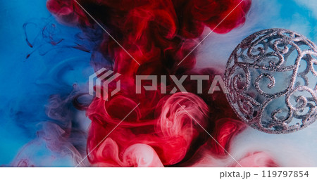 Xmas magic. Mist floating. Shimmering glitter round intricate Christmas bauble red blue paint water splash fume cloud texture abstract background. 119797854