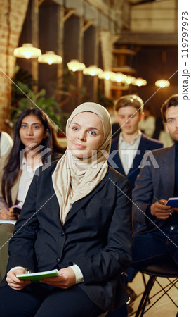 Multiracial group of business people listening attentively during seminar in modern workspace. Corporate learning in dynamic environment. 119797973