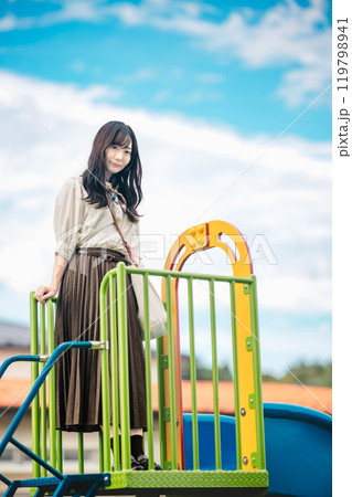 滑り台の上で楽しそうにする若い女性 119798941