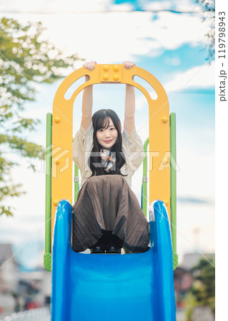 滑り台の上で楽しそうにする若い女性 119798943