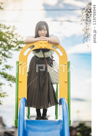滑り台の上で楽しそうにする若い女性 119798944