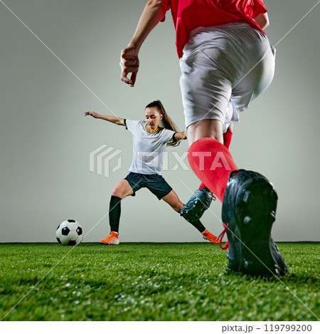 Two female soccer players focused on gaining possession of ball. Women wet after rainy outdoors training. Two female soccer players focused on gaining possession of ball. Women wet after rainy outdoors training. 119799200