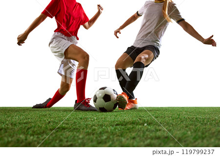 Cropped image of female soccer players in motion on stadium, dribbling ball, training against white background. Focus on legs. 119799237