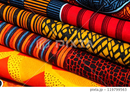 An array of fabric rolls adorned with intricate and colorful African designs An array of fabric rolls adorned with intricate and colorful African designs 119799563