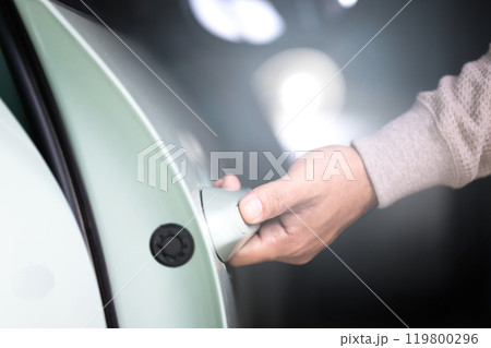 A man's hand reaching to open a car door. The image represents the concept of vehicle usage, emphasizing the everyday action of accessing and using a car responsibly A man's hand reaching to open a car door. The image represents the concept of vehicle usage, emphasizing the everyday action of accessing and using a car responsibly 119800296