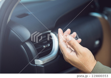 Car owner checks the air conditioning system by feeling the cool air from the vent after the vehicle has been flooded. Concept of vehicle maintenance, focusing on post-flood cooling system inspections Car owner checks the air conditioning system by feeling the cool air from the vent after the vehicle has been flooded. Concept of vehicle maintenance, focusing on post-flood cooling system inspections 119800353