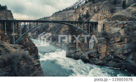 A beautifully engineered bridge stands over a roaring river, symbolizing human achievement and architectural prowess. 119803076