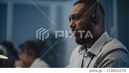 African American hotline specialist in headset providing online psychological assistance 119803279