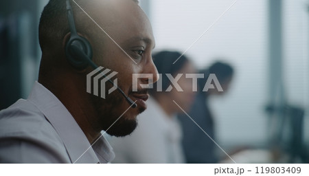 Close up of African American technical support specialist in headset helping online on phone call Close up of African American technical support specialist in headset helping online on phone call 119803409